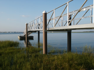 The aluminum gangway is clamped to angle irons attached to fiberglass pilings. 